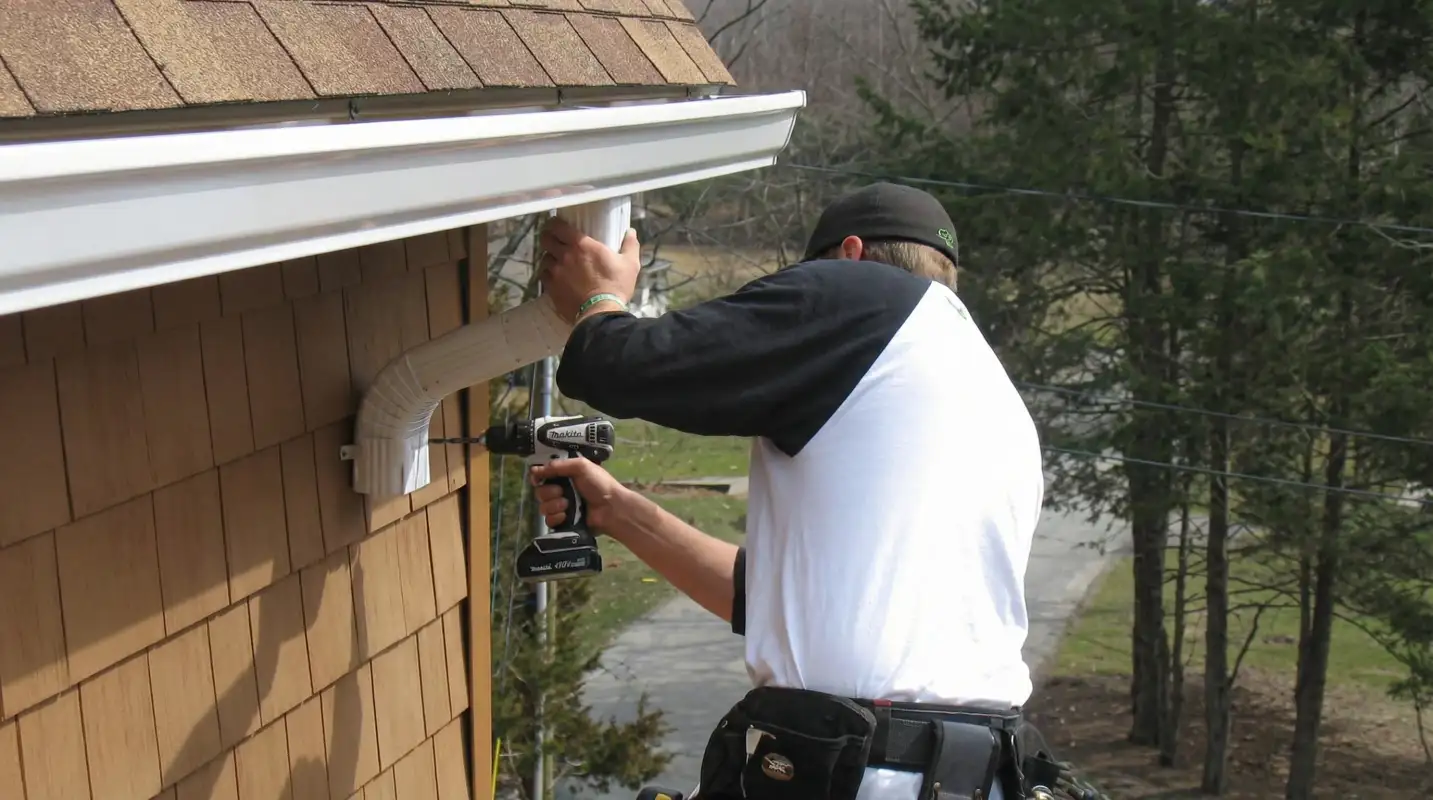 Professional contractor installing tan vinyl siding panels on a residential home exterior in Gilbert, AZ